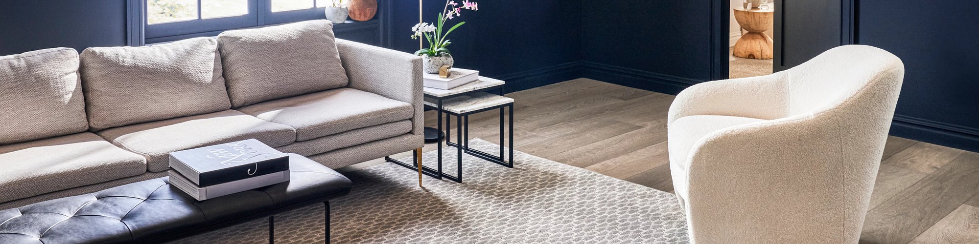 grey couch and white arm chair on area rug in living room